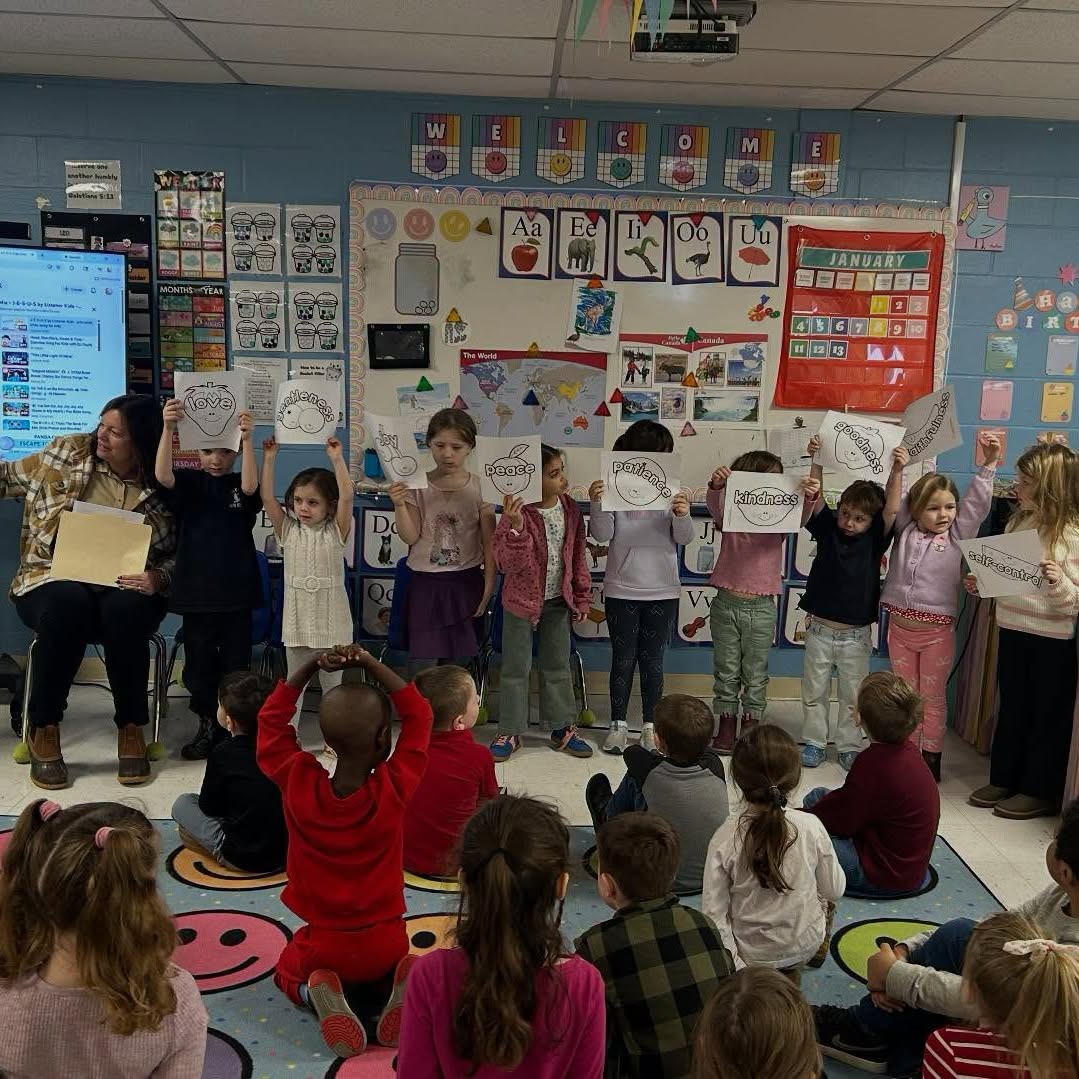 Kindergarten students holding up fruit of the Spirit posters during a class presentation