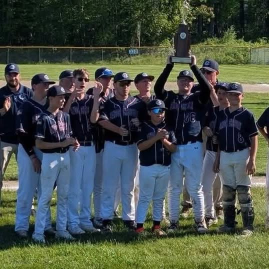The Patriots baseball team raising a championship trophy on the field
